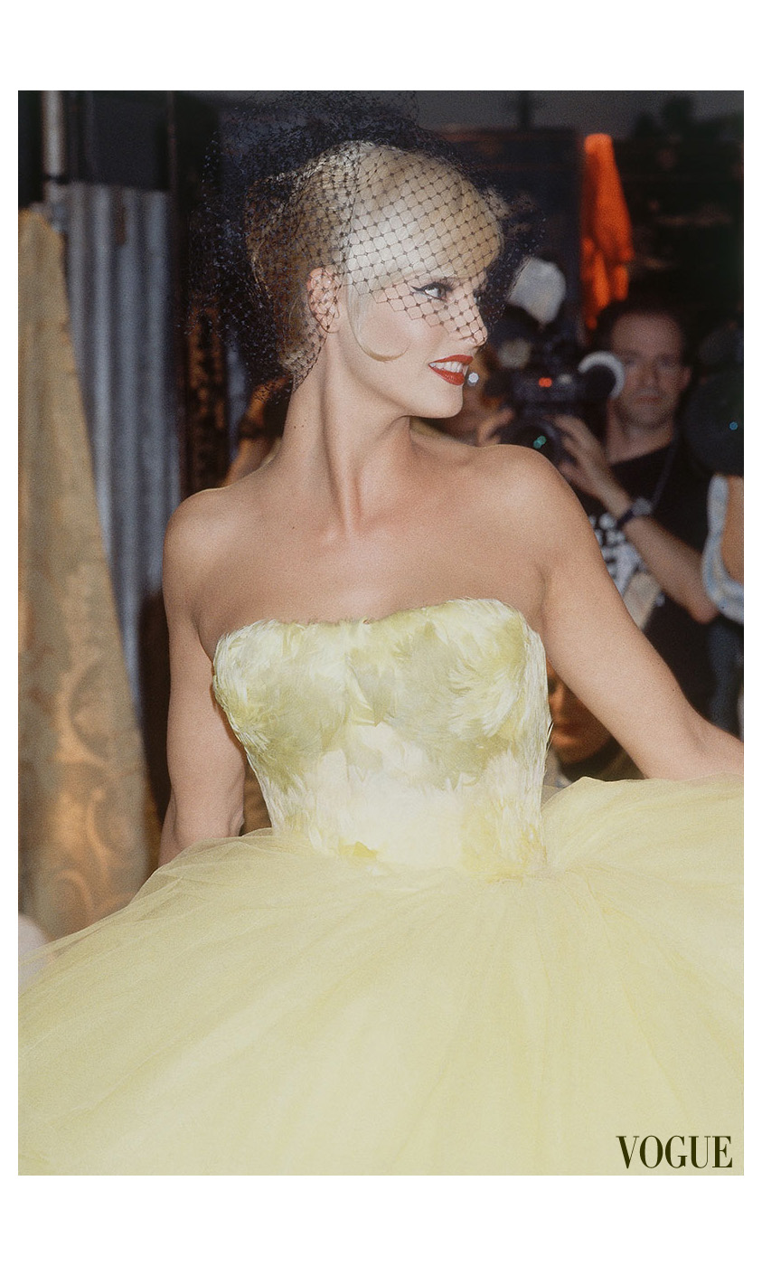 Linda Evangelista presenting a red John Galliano dress in the