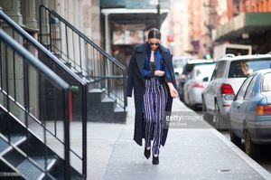 olivia-culpo-is-wearing-a-coat-from-ports-1961-stripe-pants-from-picture-id510113626.jpg