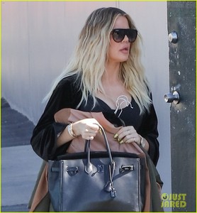 khloe-kardashian-holds-clothes-over-baby-bump-to-cover-up-02.jpg