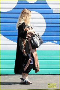 khloe-kardashian-holds-clothes-over-baby-bump-to-cover-up-03.jpg