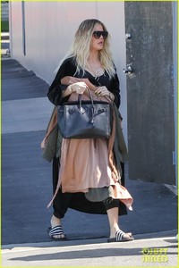 khloe-kardashian-holds-clothes-over-baby-bump-to-cover-up-05.jpg