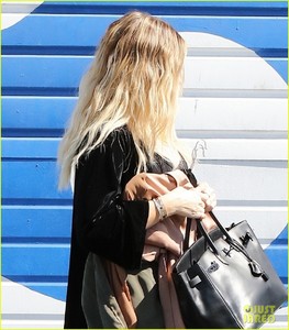 khloe-kardashian-holds-clothes-over-baby-bump-to-cover-up-06.jpg