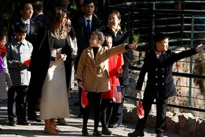 462F876E00000578-5068689-A_group_of_school_children_holding_Chinese_and_American_flags_we-a-83_1510292015346.jpg