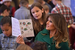 474CAC7A00000578-5176441-Melania_took_great_care_reading_one_little_girl_s_Christmas_card-a-13_1513203151295.jpg