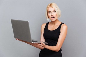 stock-photo-amazed-unhappy-young-woman-using-laptop-over-gray-background-479554783.jpg