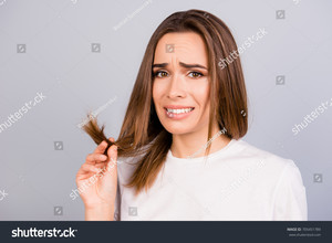 stock-photo-oh-no-close-up-portrait-of-frustrated-young-brown-haired-woman-holding-her-hair-wih-separated-dry-705451789.jpg