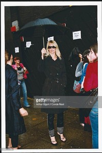 599771159rrying an umbrella in the rain during London Fashion Week.9-2003.jpg