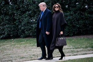 9880688-6710843-The_first_lady_wrapped_up_warm_in_a_2300_Ferragamo_cape_and_held-a-5_1550275124469.jpg