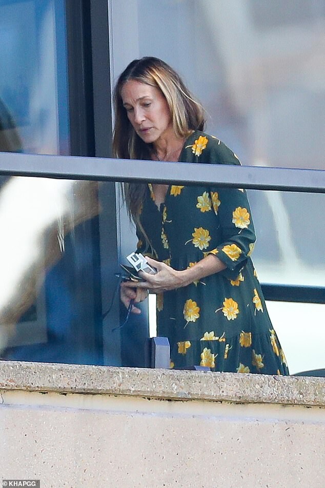 Sarah Jessica Parker smokes a cigarette on her Sydney Harbour hotel balcony...