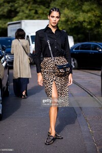 iris-mittenaere-wearing-a-black-shirt-leopard-print-midi-skirt-black-picture-id1177117256.jpg