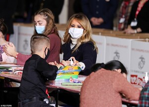 36603552-9030983-The_first_lady_helps_one_of_the_children_apply_hand_sanitizer_du-a-34_1607460467457.jpeg