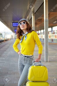 63287585-belle-jeune-femme-avec-une-valise-est-en-attente-d-un-train.jpg