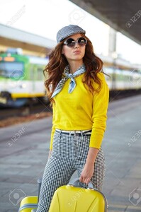 63287691-belle-jeune-femme-avec-une-valise-est-en-attente-d-un-train.jpg