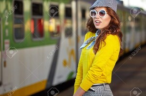 63287702-belle-jeune-femme-avec-une-valise-est-en-attente-d-un-train.jpg