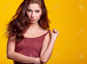 52242487-sensuelle-jeune-femme-avec-maquillage-naturel-posant-sur-fond-jaune-vif-copiez-espace-cosmétiques-soin.jpg