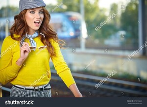 stock-photo-pretty-adult-woman-with-a-suitcase-near-the-train-on-the-platform-576018226.jpg