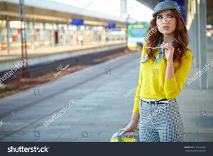 stock-photo-pretty-adult-woman-with-a-suitcase-near-the-train-on-the-platform-576018289.jpg
