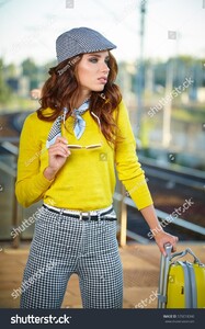 stock-photo-pretty-adult-woman-with-a-suitcase-near-the-train-on-the-platform-576018346.jpg