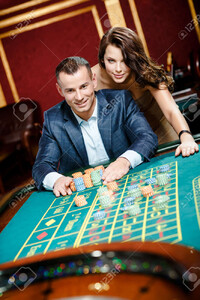 17824651-man-accompanied-by-woman-placing-bets-at-the-roulette-table.jpg