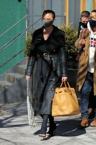 chrissy-teigen-in-a-full-length-black-leather-coat-and-open-toe-high-heels-ny-03-07-2021-6.jpg