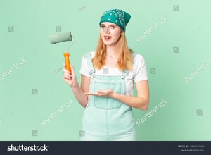 stock-photo-pretty-red-head-woman-smiling-cheerfully-feeling-happy-and-showing-a-concept-painting-home-concept-2100708910.jpg