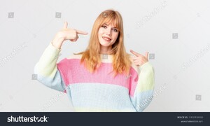 stock-photo-pretty-red-head-woman-smiling-confidently-pointing-to-own-broad-smile-2100708919.jpg