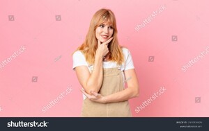 stock-photo-pretty-red-head-woman-smiling-with-a-happy-confident-expression-with-hand-on-chin-2100708679.jpg
