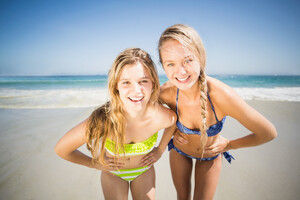 21724774_two-happy-women-standing-on-the-beach-with-hand-on-hip.jpg