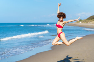 52603134_active-female-jumping-on-sandy-seashore.jpg