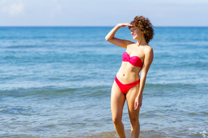 53055402_slim-woman-in-bikini-standing-in-seawater.jpg