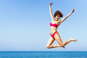 53055422_happy-woman-in-bikini-jumping-with-raised-arms.jpg