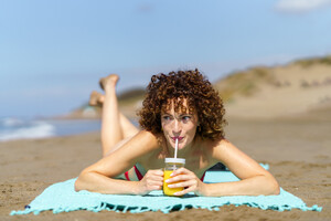 53055458_happy-woman-with-cool-drink-on-beach.jpg