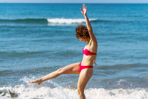 53729310_delighted-young-lady-kicking-waves-on-beach-on-sunny-day.jpg