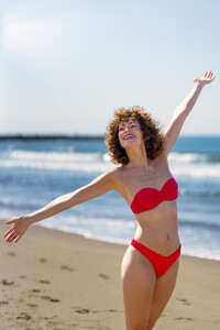 53729320_smiling-woman-standing-on-sandy-beach-in-daylight.jpg