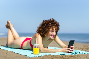 53729342_laughing-woman-using-phone-on-coastline.jpg