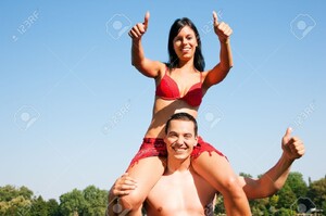 11911755-Couple-dans-l-amour-Femme-en-bikini-assis-sur-ses-paules-mans-sous-le-ciel-bleu-t-et-le-plaisir-Banque-d_images.jpg