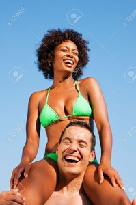 11911888-Couple-dans-l-amour-Femme-de-couleur-en-bikini-assis-sur-ses-paules-mans-sous-le-ciel-bleu-t-et-le-p-Banque-d_images.jpg