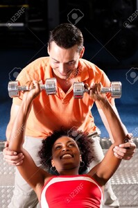 11912294-Femme-avec-son-entra-neur-personnel-dans-le-gymnase-exercice-avec-des-halt-res-Banque-d_images.jpg