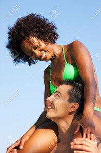 11912310-Couple-dans-l-amour-Femme-de-couleur-en-bikini-assis-sur-ses-paules-mans-sous-le-ciel-bleu-t-et-le-p-Banque-d_images.jpg
