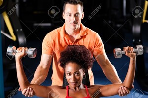 11912347-Femme-avec-son-entra-neur-personnel-dans-le-gymnase-exercice-avec-des-halt-res-Banque-d_images.jpg