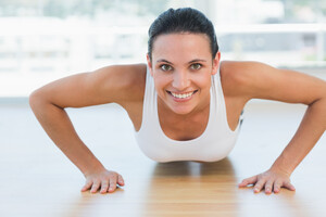 12147078_smiling-beautiful-woman-doing-push-ups-in-gym.jpg