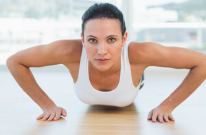 12147136_determined-beautiful-woman-doing-push-ups-in-gym.jpg