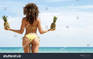 stock-photo-beautiful-woman-with-curly-hair-is-holding-pineapple-fruit-on-the-beach-653990284.jpg