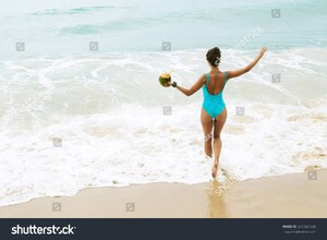 stock-photo-happy-and-beautiful-in-swimsuit-with-a-coconut-on-the-beach-661547320.jpg
