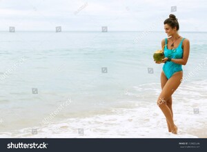 stock-photo-happy-and-beautiful-in-swimsuit-with-a-coconut-on-the-beach-739825246.jpg