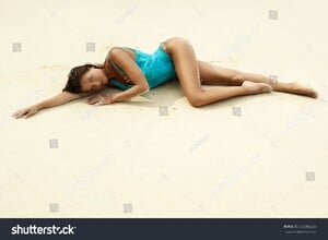 stock-photo-sexy-woman-in-blue-swimsuit-covered-with-sand-on-the-beach-663306826.jpg