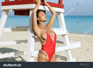 stock-photo-sexy-woman-in-red-swimsuit-posing-beside-a-lifeguard-tower-654047458.jpg