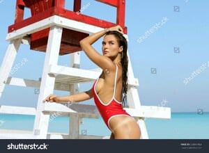 stock-photo-sexy-woman-in-red-swimsuit-posing-beside-a-lifeguard-tower-654047464.jpg
