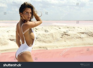 stock-photo-sexy-woman-in-white-swimsuit-posing-on-the-beach-beside-a-lake-with-pink-water-661553002.jpg