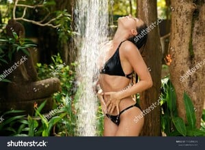 stock-photo-sexy-woman-wearing-black-bikini-taking-shower-in-tropical-garden-in-resort-1115890376.jpg